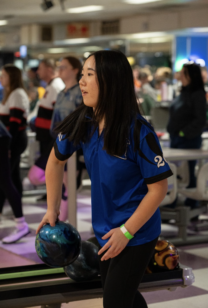 Lily Grau (10) picks out her ball, getting ready to bowl. 